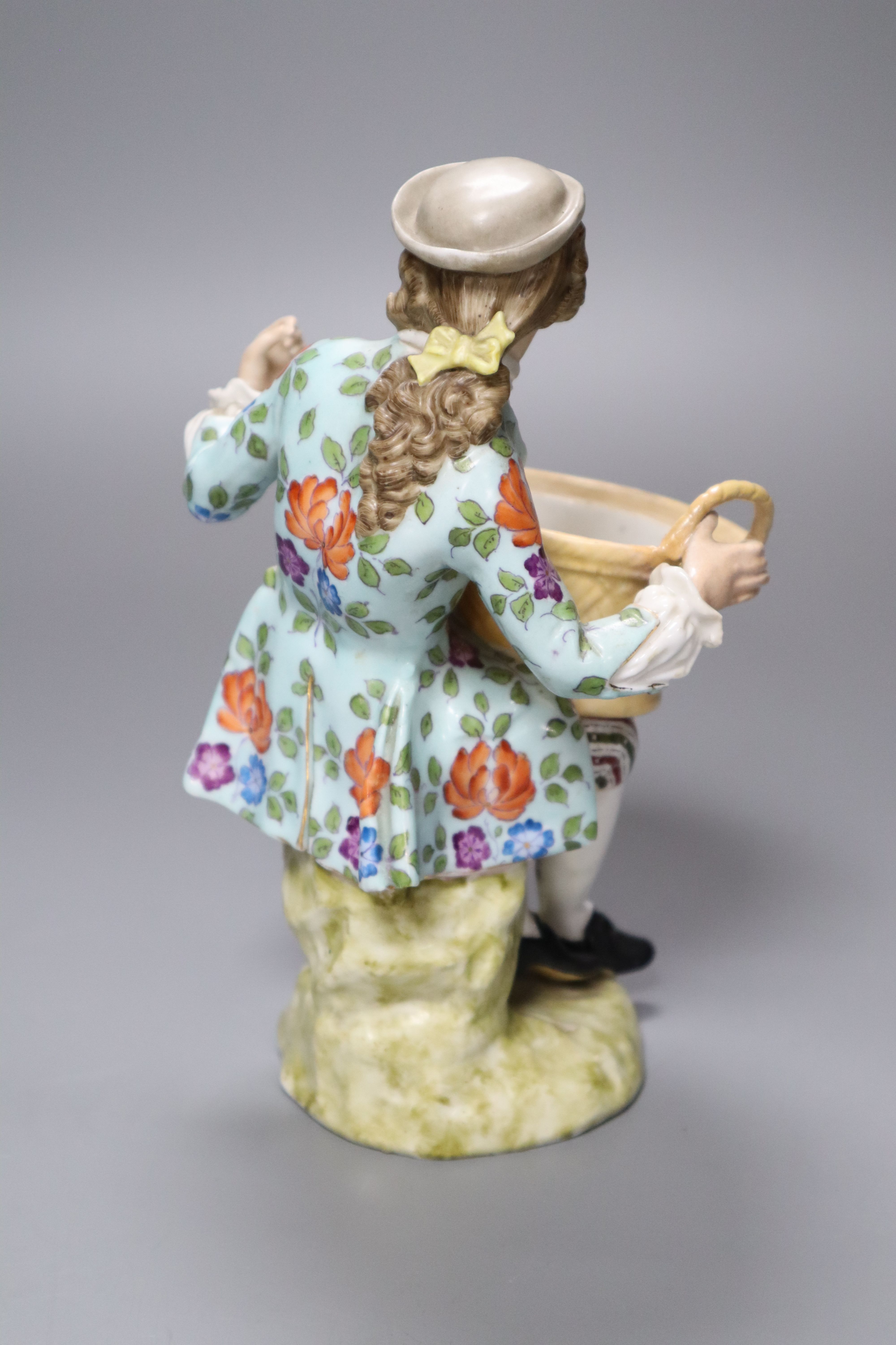 A Sitzendorf porcelain figure of a youth holding a basket, after a Meissen original by J.J. Kaendler, height 19cm